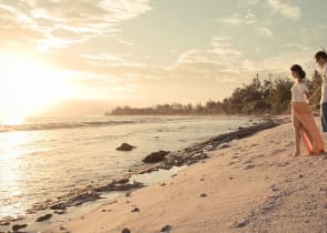 Honeymoon couple on the beach in Moorea, Tahiti.  Photo courtesy Tahiti Tourisme/Hélène Havard