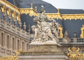 Statue and ornate architecture of Versailles in France.