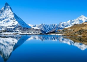 The Matterhorn summit is reflected in the glacial lake of the Swiss Alpine waters.