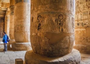 Traveler viewing hieroglyphs on the walls of the Temple of Medinet Habu in Egypt