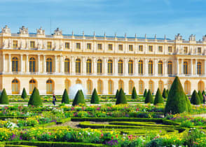 Lush green garden and Versailles building in France