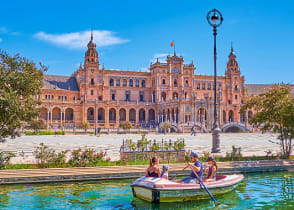 Family boating in the canal at Plaza de Espana in Seville, Spain