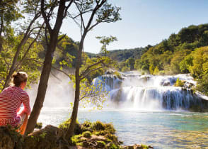 Woman traveler relaxing and viewing the waterfalls in Krka National Park, Croatia