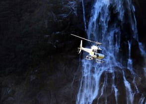 Helicopter flies over Fiordland National Park, New Zealand