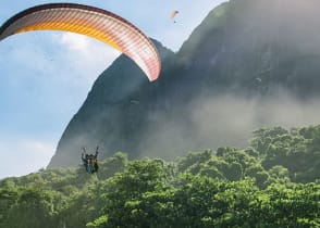 Couple on a romantic paragliding flight over the coast of Brazil