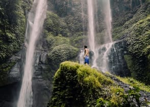 Traveler looking up at Sekempul Waterfall in Bali