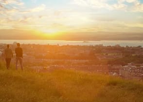 Couple enjoying cityscape at sunset, Edinburgh, Scotland, UK