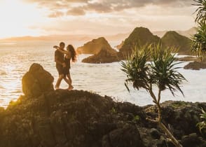 Honeymoon couple at sunset on the rock in Bali, Indonesia