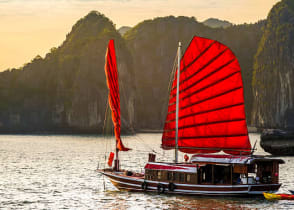 A red junk boat sailing in Ha Long Bay in Vietnam.