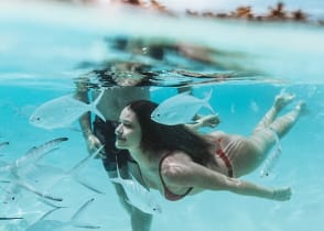 A couple swims in the ocean in the Maldives