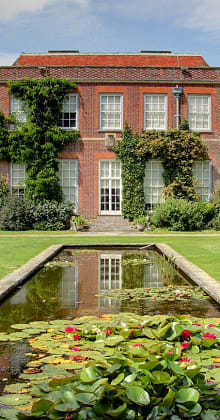 Historic red-brick house with lily pond and rose gardens at Mottisfont Abbey in Hampshire, England, UK