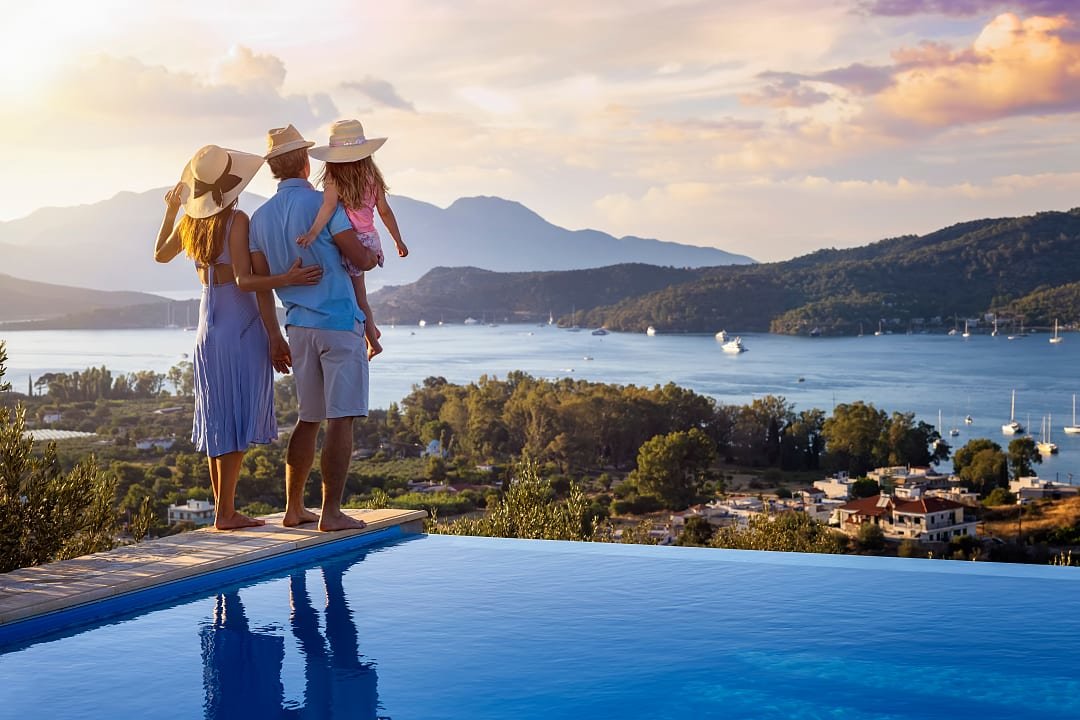 Family enjoying the poolside view from a resort in Poros, Greece