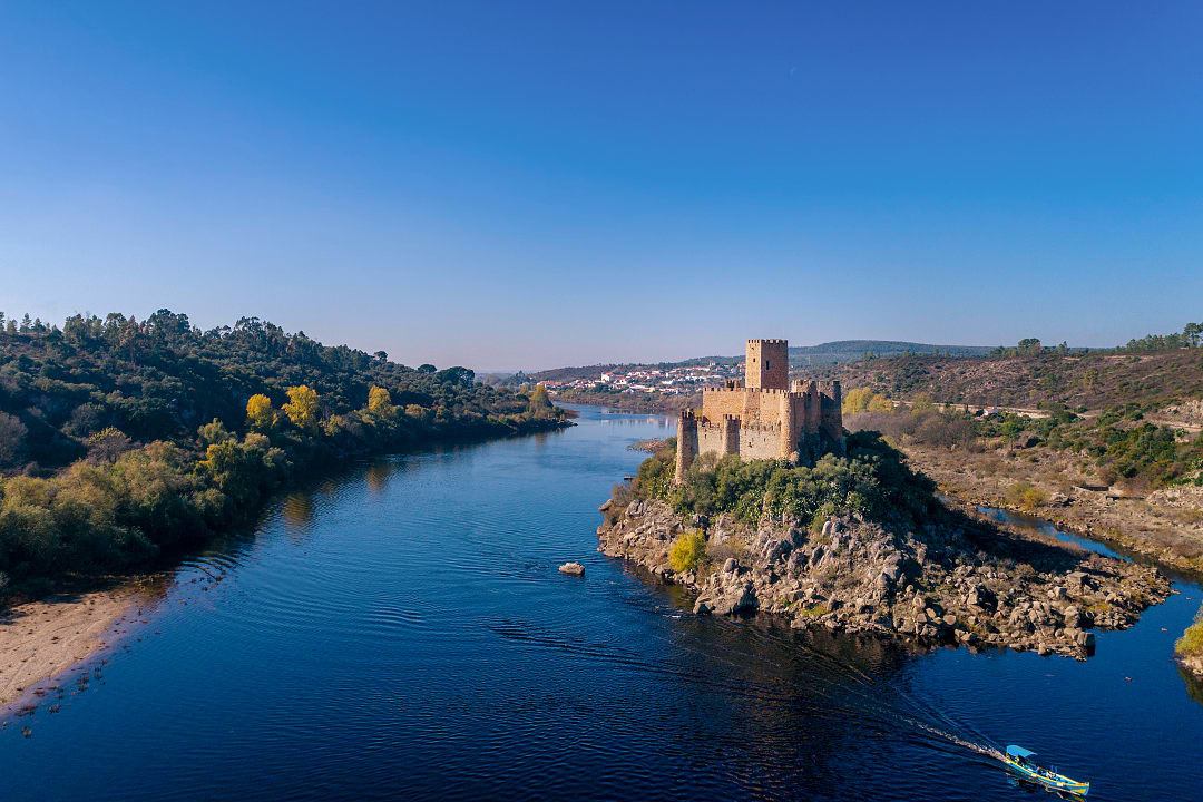 Boat passing Castelo de Almourol on the Tagus river in Portugal