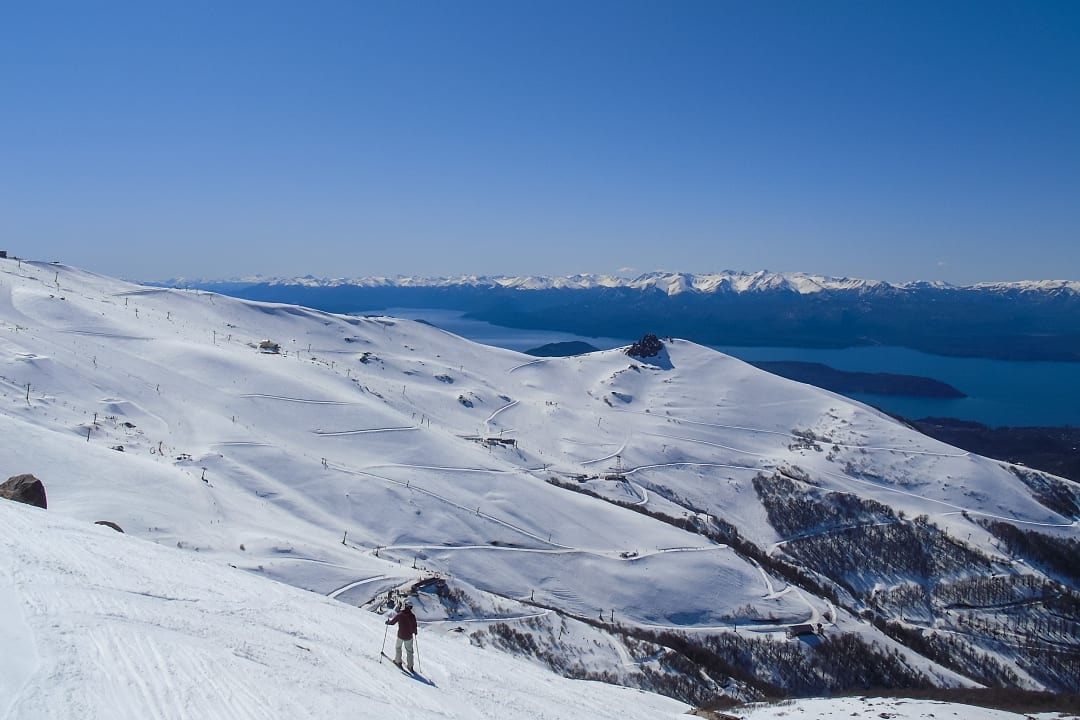 A skier enjoys breathtaking mountain views in snowy Bariloche, Argentina.