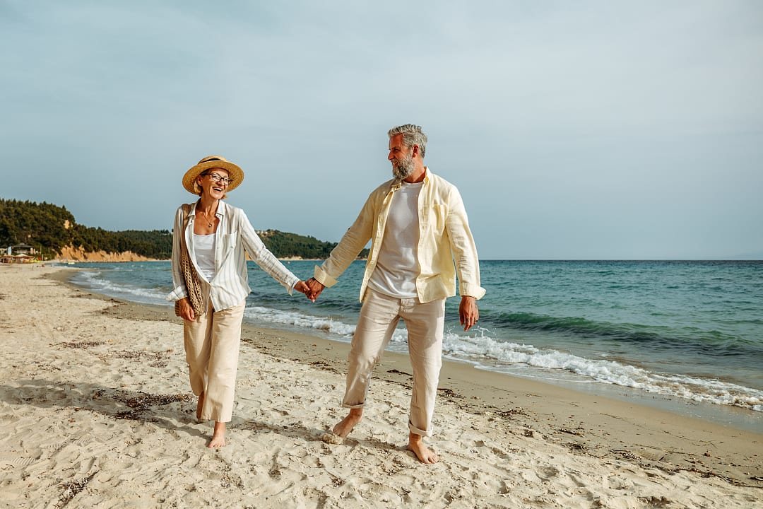 A couple enjoys a walk on the beach in Greece
