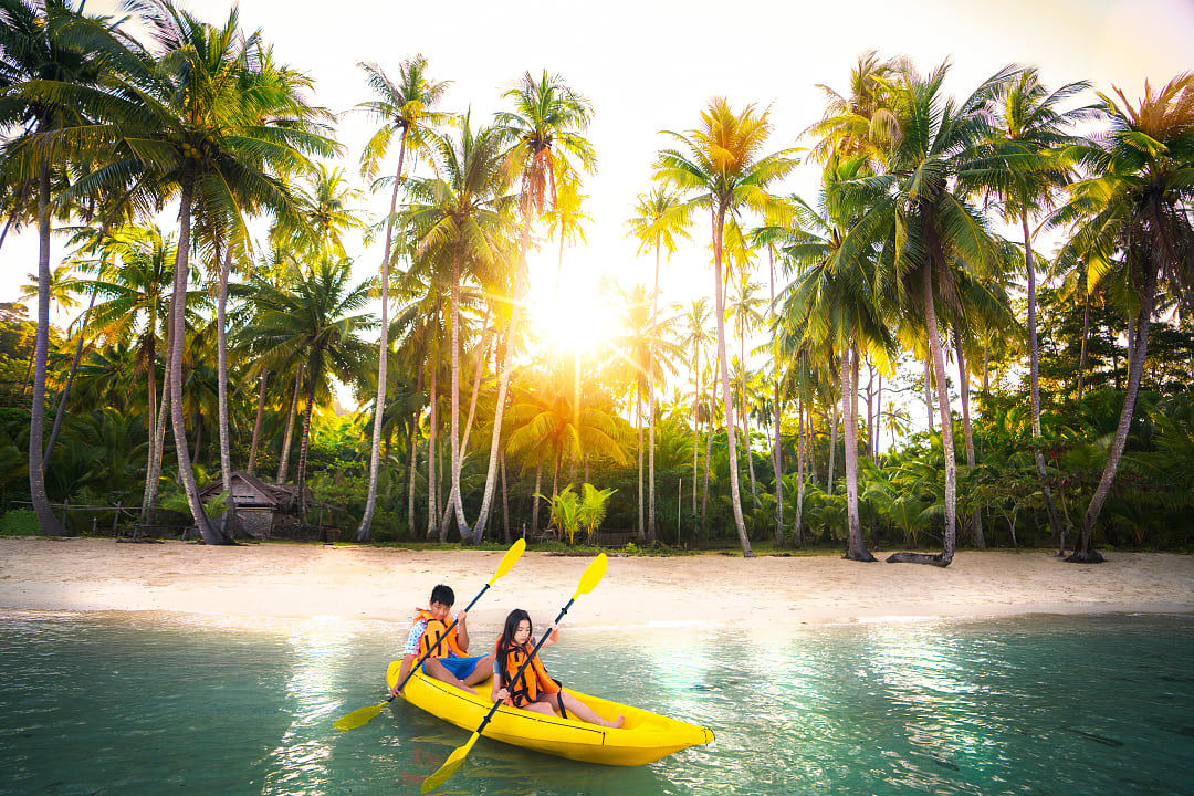 Young brother and sister kayaking in Koh Kood, Thailand