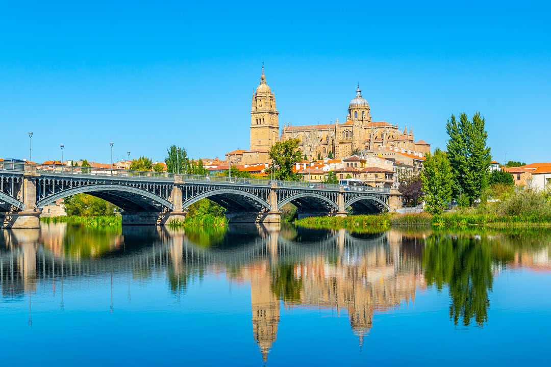 The Roman Bridge and Salamanca Cathedral seen from the riverside Paseo along the Tormes, Salamanca.