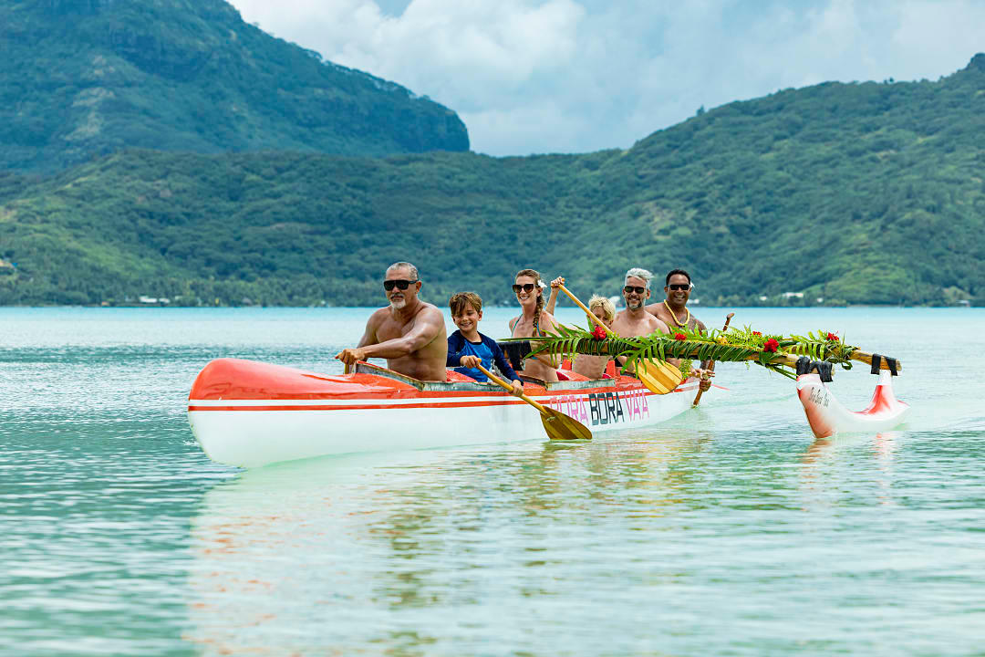 Family rowing an outrigger in Bora Bora, French Polynesia