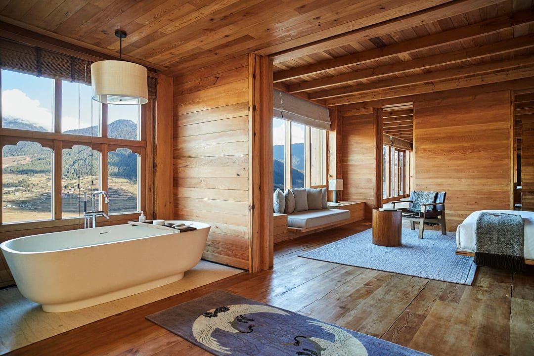 Luxury suite at Six Senses Bhutan with a freestanding bathtub and panoramic mountain views