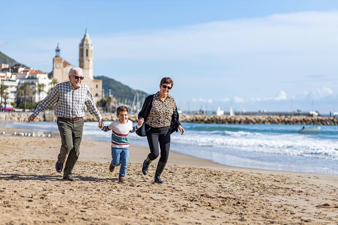 A boy takes his grandparents for a run on the beach in Spain