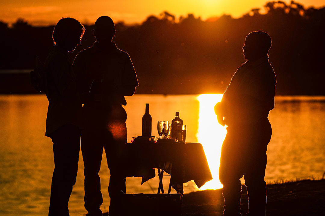 A couple enjoying sundowners on the Luangwa river.