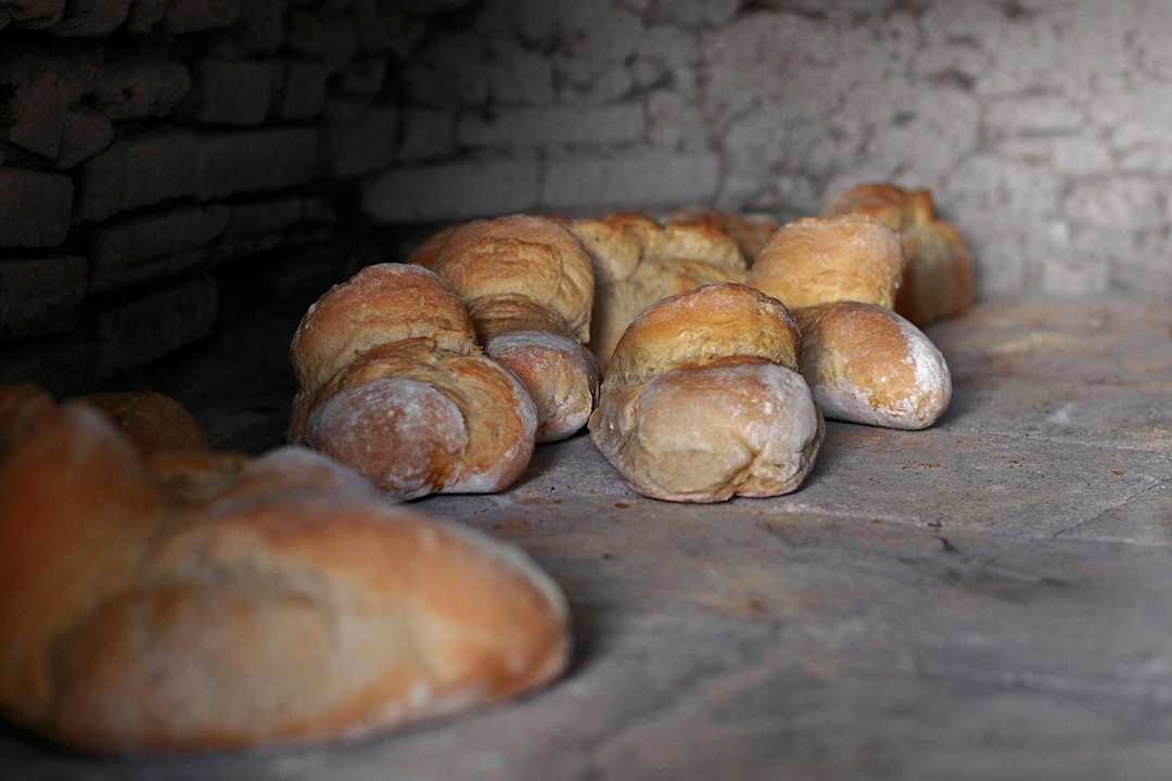 Freshly baked rustic bread cooling inside a traditional stone oven in Portugal