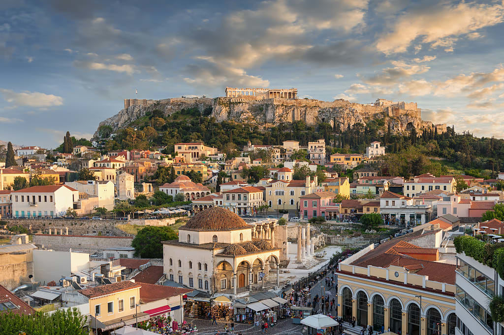 View of the Parthenon Temple of the Acropolis and the old town Plaka in Athens at sunset.