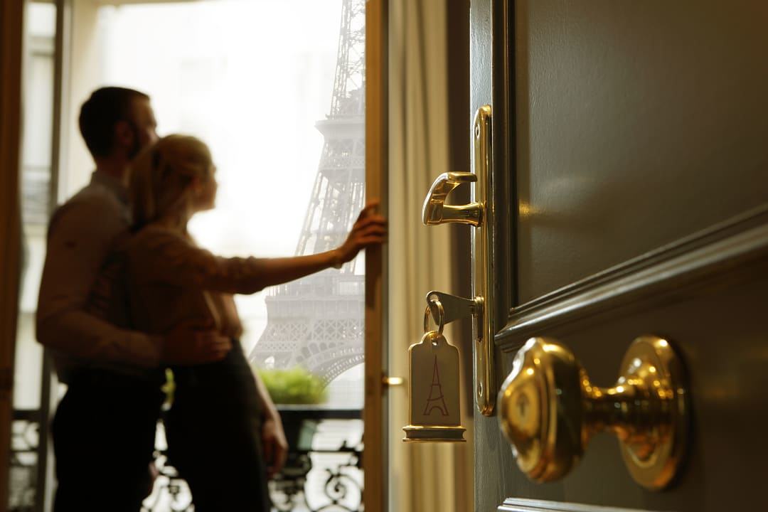 Couple enjoying the view of the Eiffel Tower from their hotel balcony.