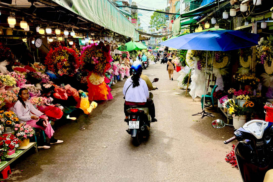 Motorbike passing through flower market in Ho Chi Minh City, Vietnam