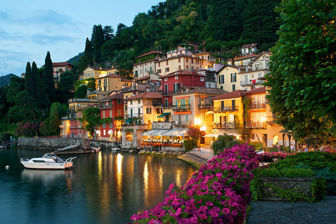 Colorful hillside villas overlooking the calm waters of Lake Como at dusk, Italy.