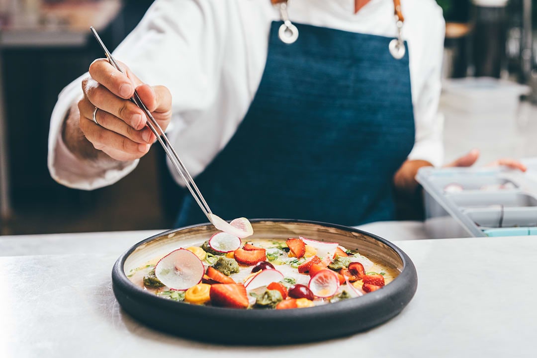 French chef dishing out an intricate plate.