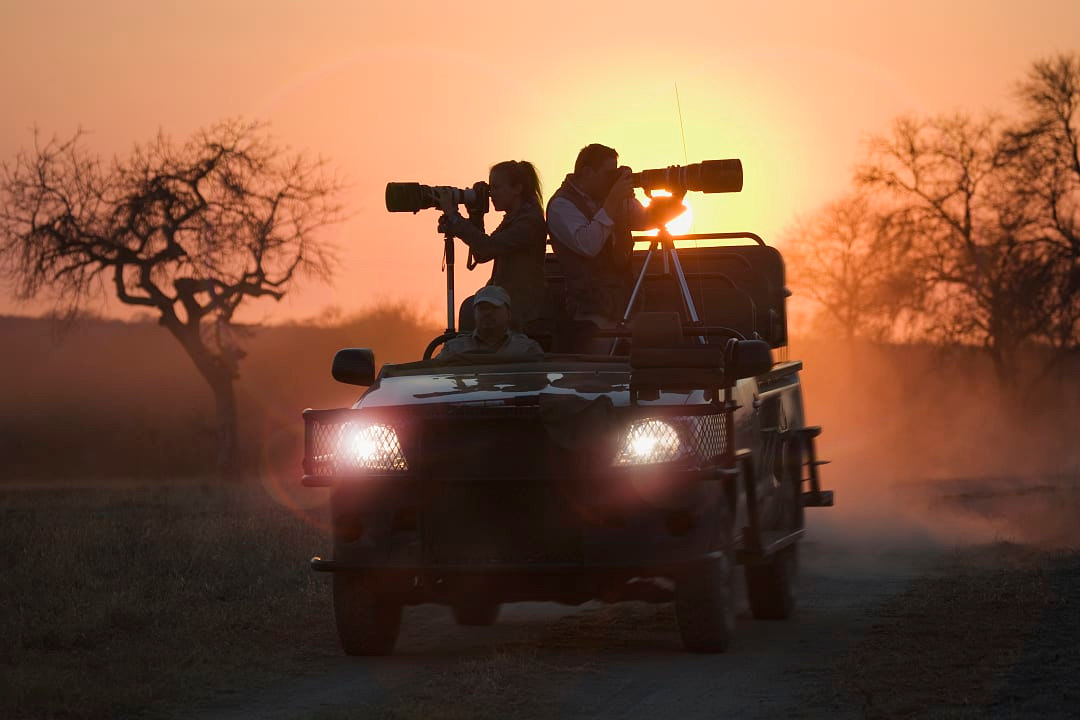 Two photographers enjoying a private safari during sunset.