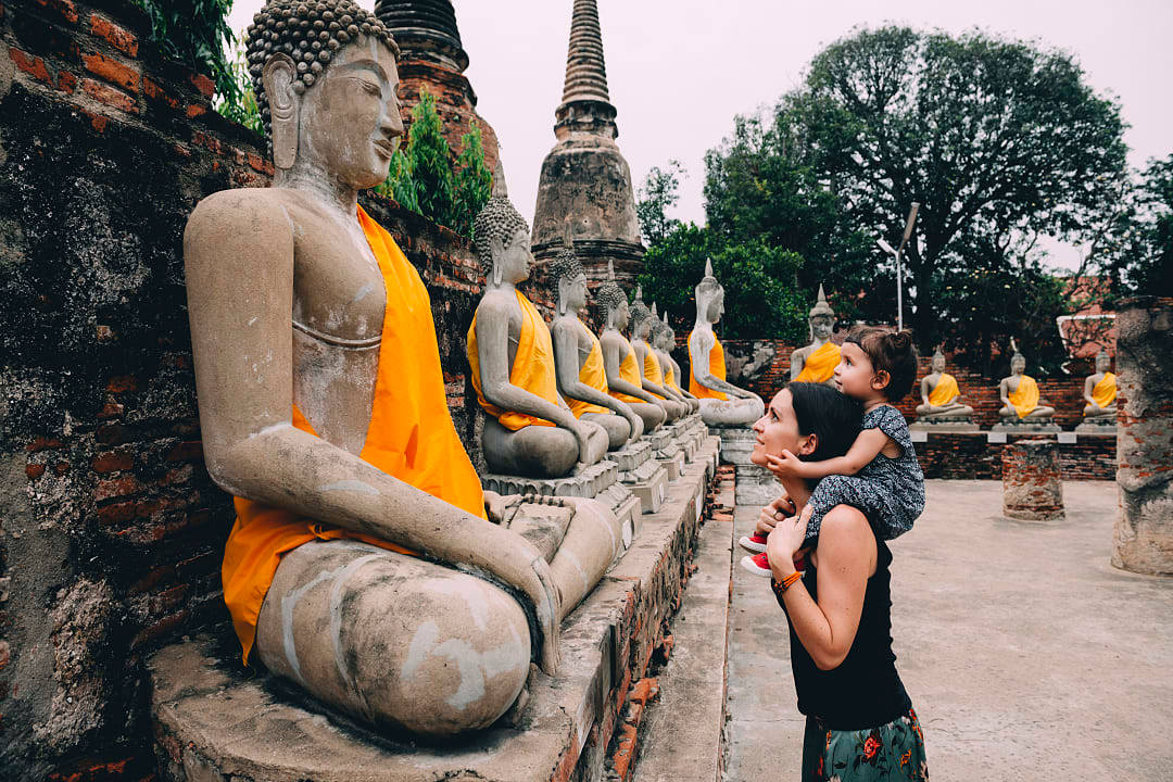 Mother and child admiring Buddha statues at Wat Yai Chai Mongkhon in Ayutthaya, Thailand