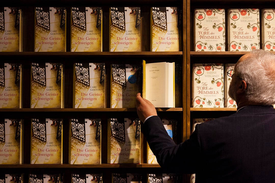Visitor with a wall of books at the Frankfurter Buchmesse in Germany