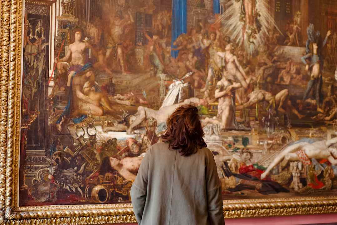 Woman looking at a painting in a museum in Paris.