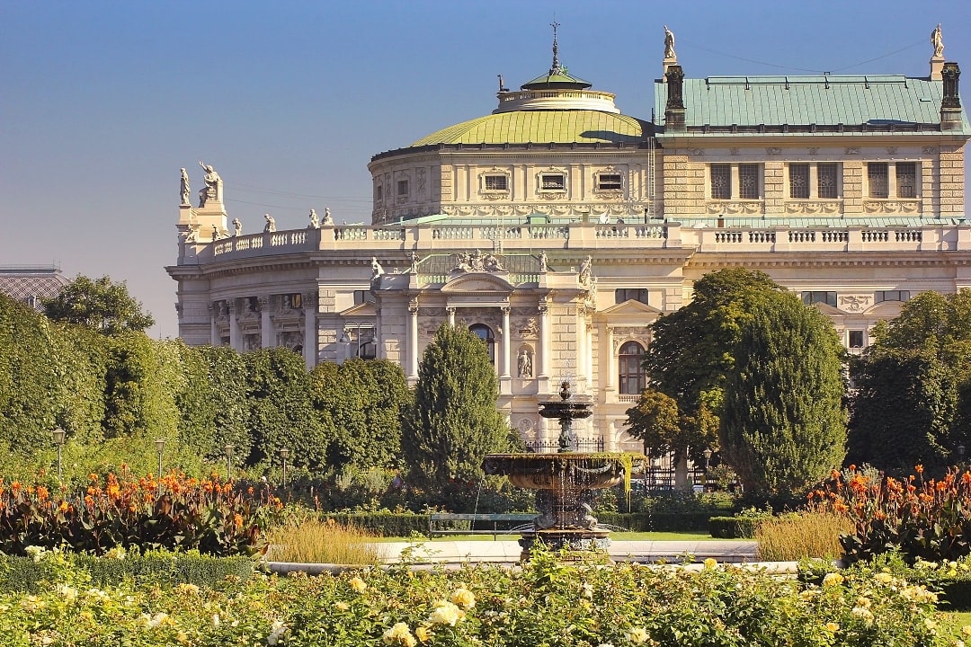 ountain and flowers in Volksgarten with the Burgtheater in the background, Vienna, Austria