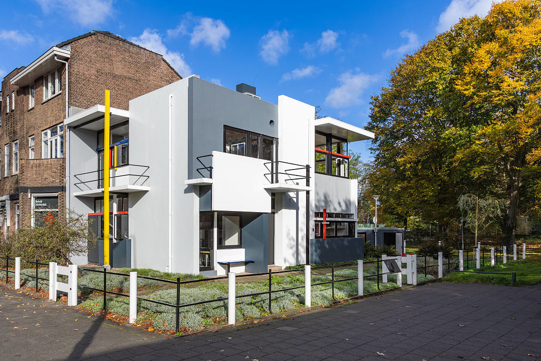 The geometric exterior of the Rietveld Schröder House featuring primary colors and intersecting vertical and horizontal lines.