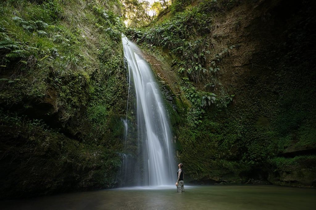 Man inside the Te Ana falls in Hawkes Bay, New Zealand.