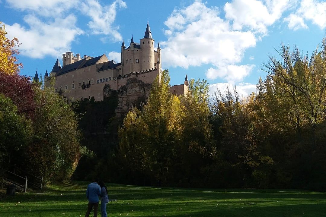 Couple in a park with a view of the Alcázar in Segovia, Spain