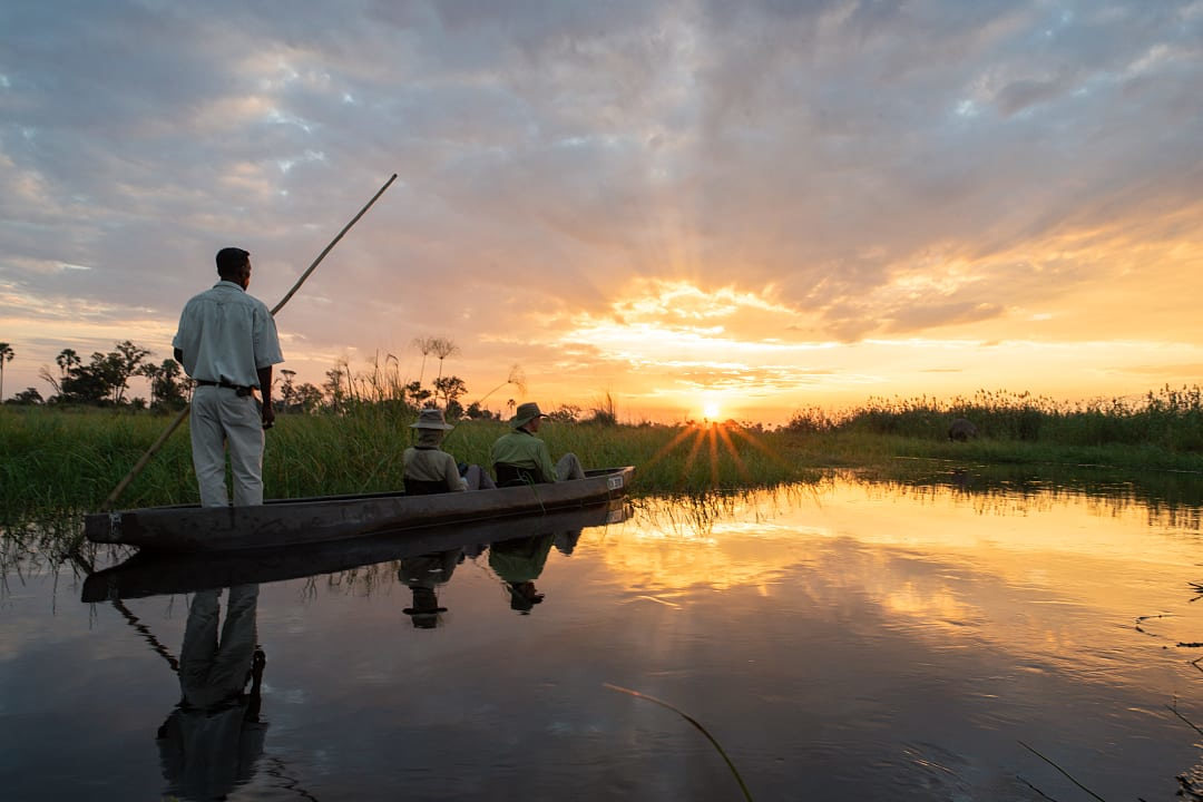 Couple on a guided sunset mokoro boat ride in Botswana