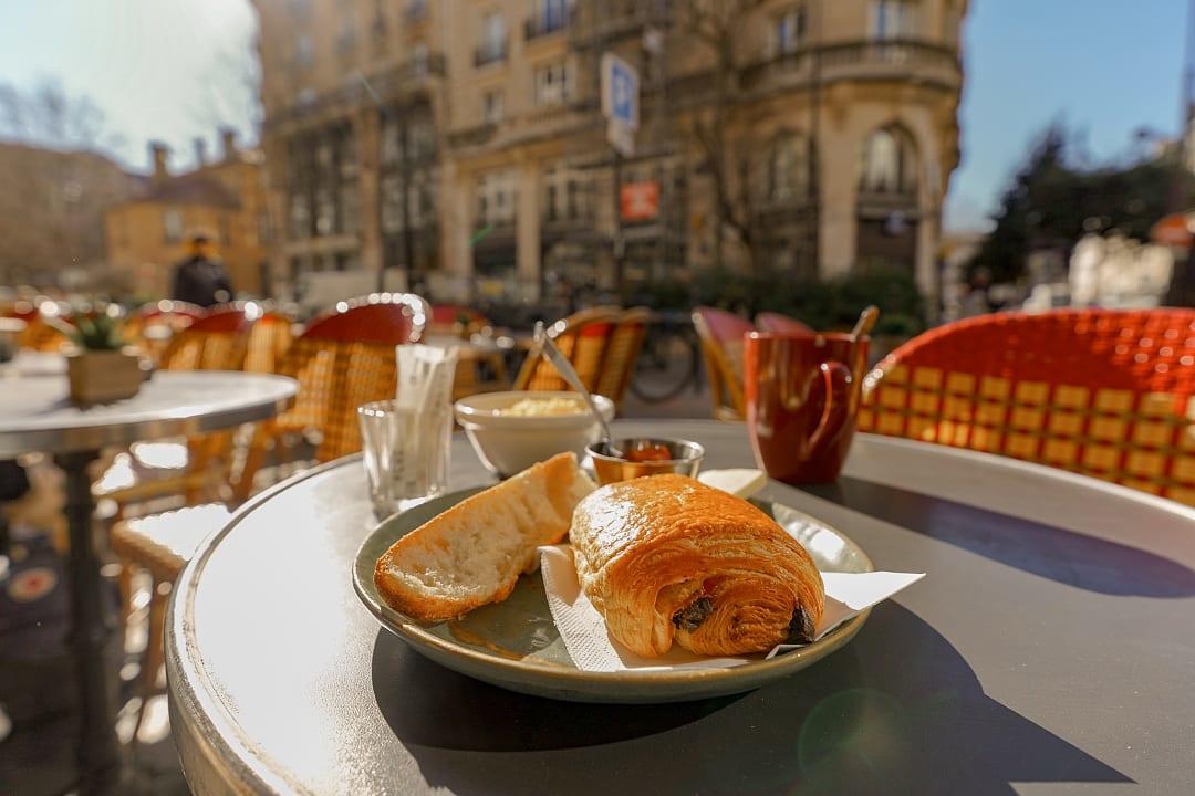 A Parisian café breakfast with fresh pastries and warm morning sunlight.