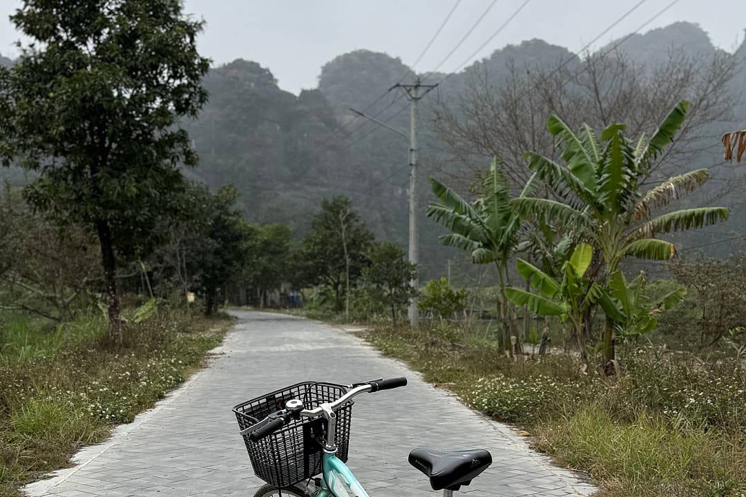 Bicycle on a rural road with limestone karst hills in Tam Cốc, Ninh Bình, Vietnam