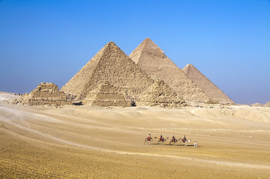Camel caravan crossing on the Giza Plateau and Giza pyramid complex 