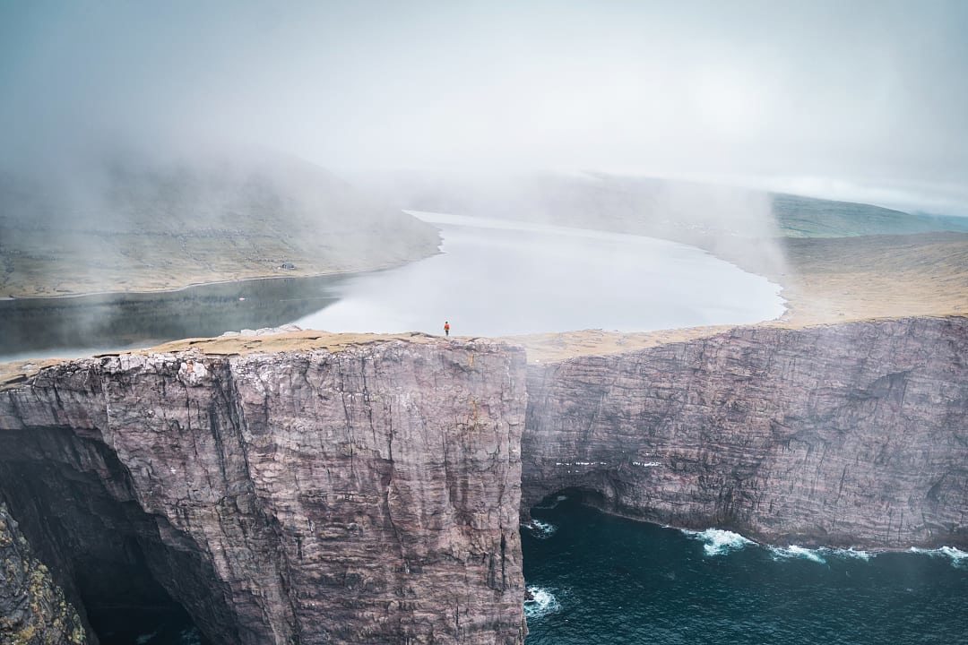 Aerial view of Sørvágsvatn Lake, the famous “floating lake” illusion above the North Atlantic Ocean, as seen from the Trælanípa cliffs in the Faroe Islands.