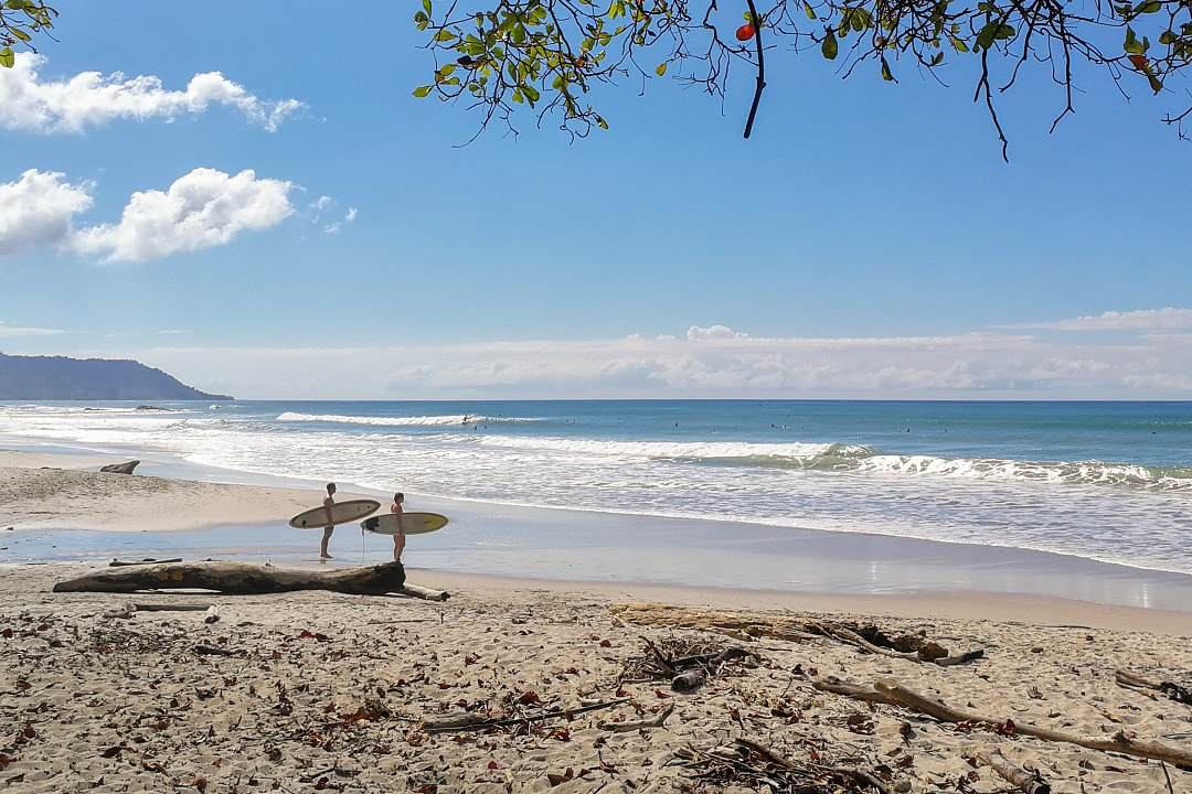 Two surfers standing on Santa Teresa beach, Costa Rica