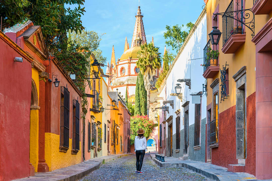 Woman walking on the cobblestone street in colorful San Miguel de Allende, Mexico
