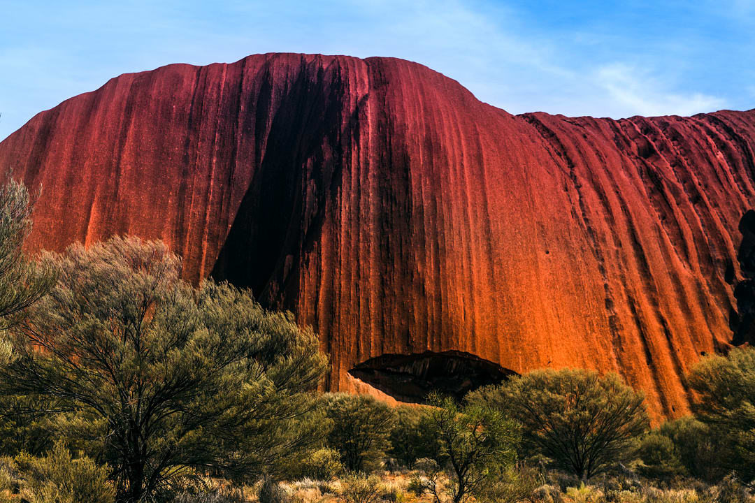 Massive red sandstone rock formation against blue sky