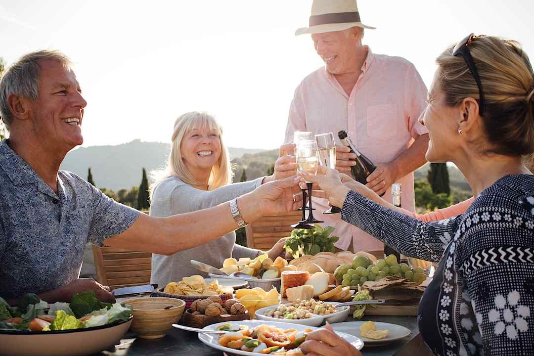 Group of people enjoying a slow lunch in Tuscany.