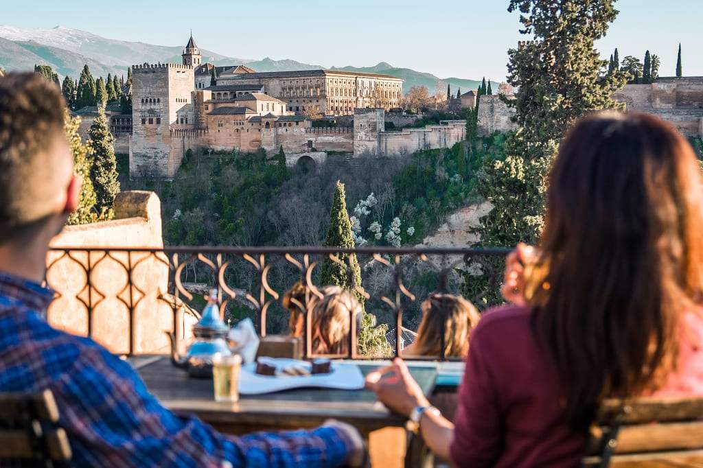 Couple enjoying a view of the Alhambra from a restaurant in Granada, Spain.  Photo © Turismo Andaluz