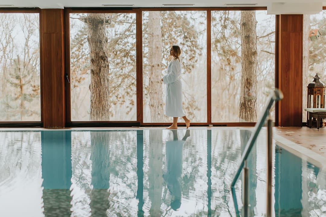 Woman walking poolside at a wellness resort and spa